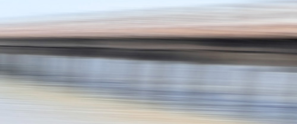 a blurry photo of a bridge over water