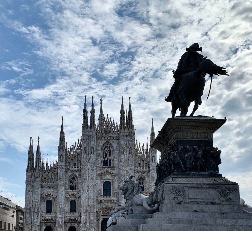 a statue of a man on a horse in front of a cathedral