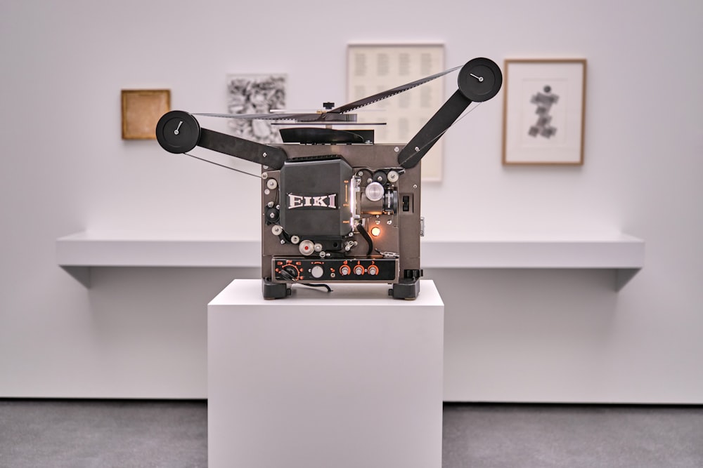 a camera sitting on top of a white pedestal