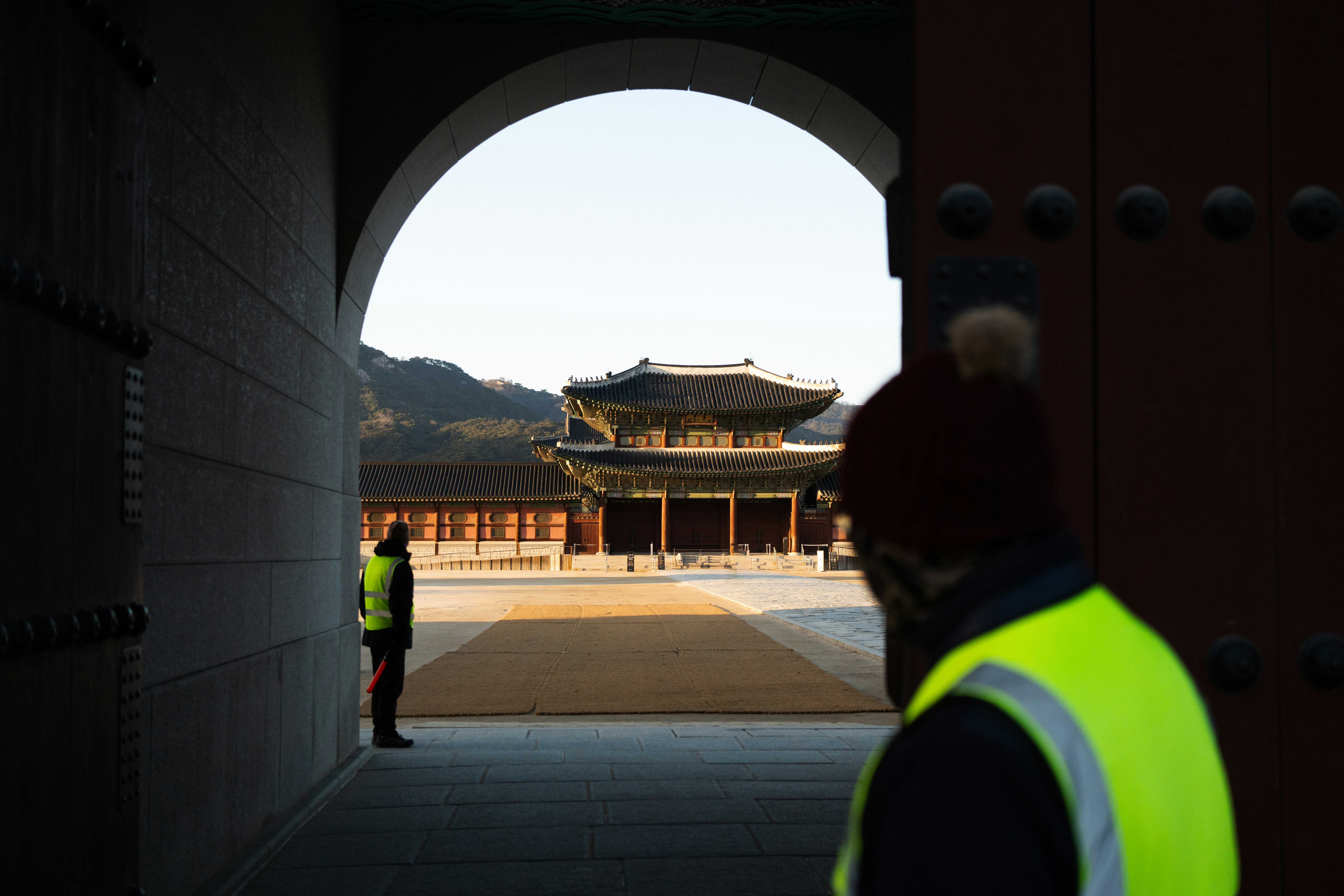 건설퇴직공제금신청 - a man in a yellow vest standing in front of a building