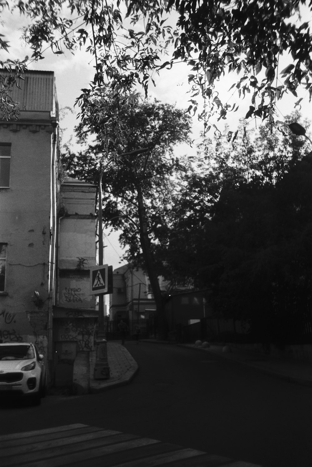 a car parked on the side of a road next to a tall building