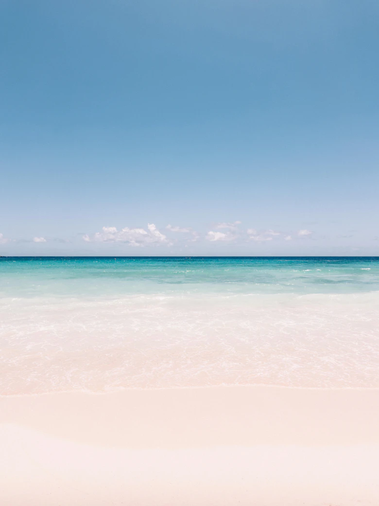 Strand met turquoise zee en een boot in de verte