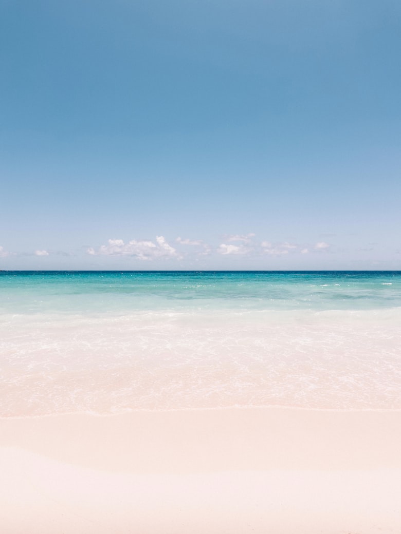 Strand met turquoise zee en een boot in de verte