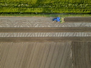 an aerial view of a tractor plowing a field