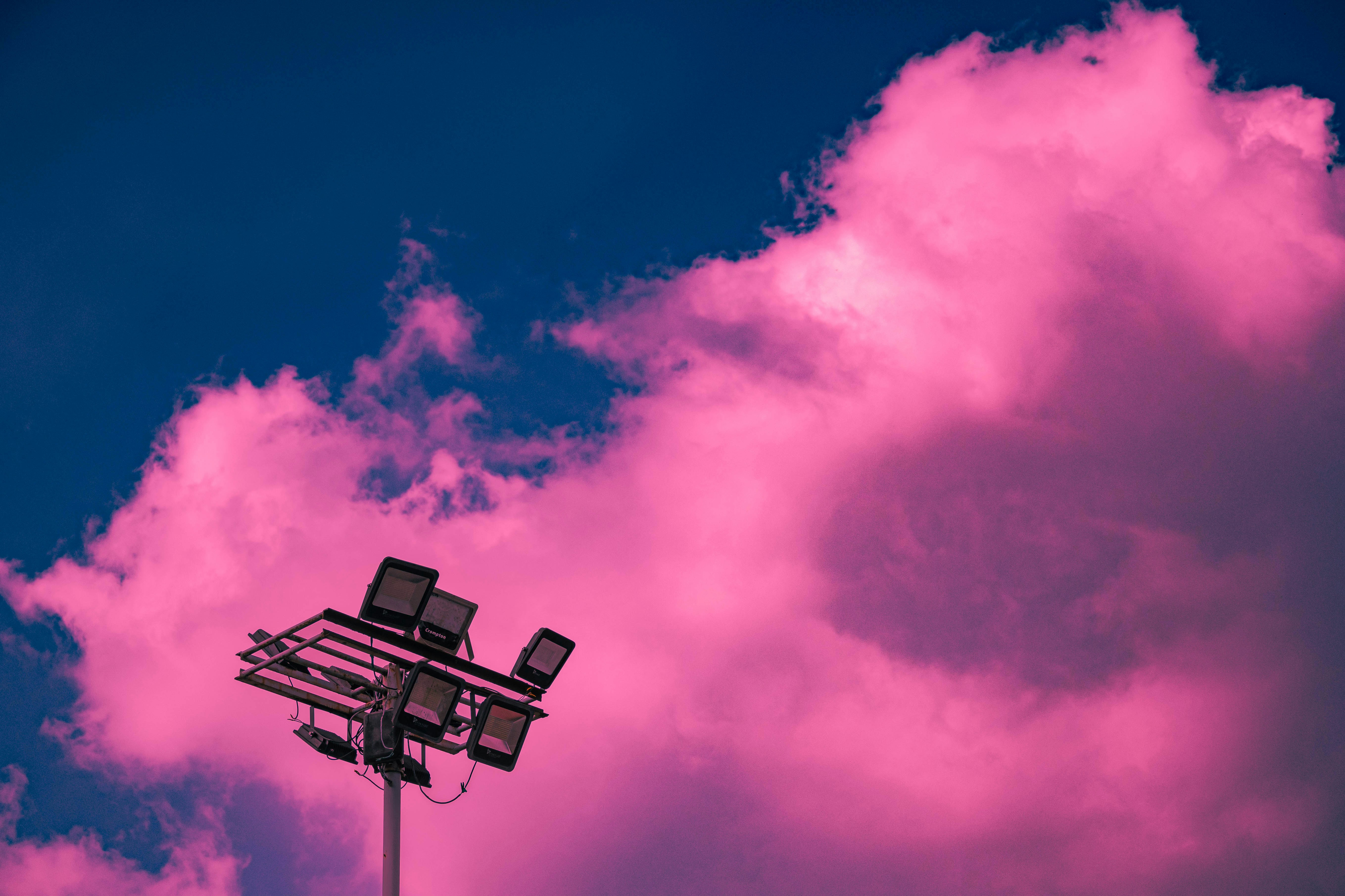 a street light with a pink sky in the background