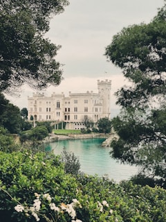 a large white house sitting on top of a lush green hillside