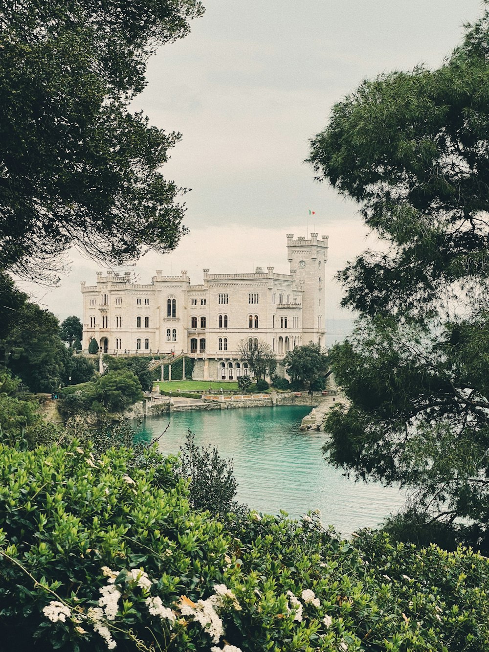 a large white house sitting on top of a lush green hillside