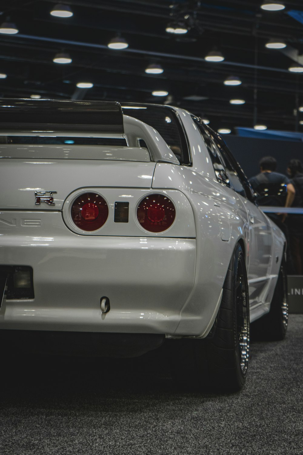 the back end of a white car on display