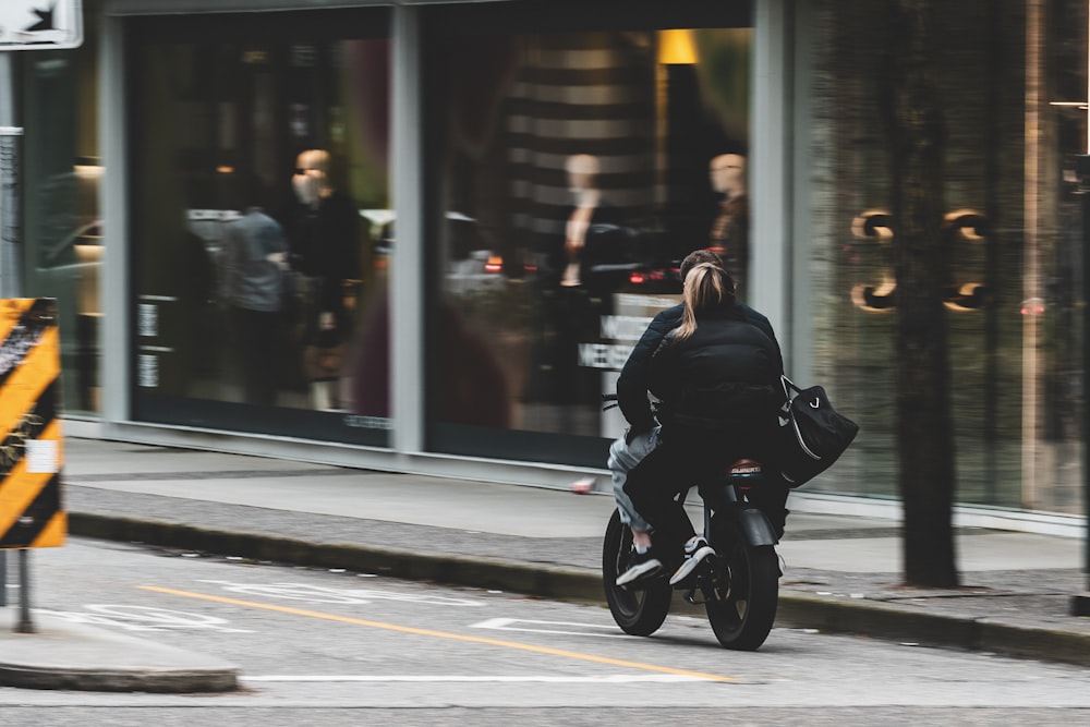 uma pessoa andando de moto em uma rua da cidade