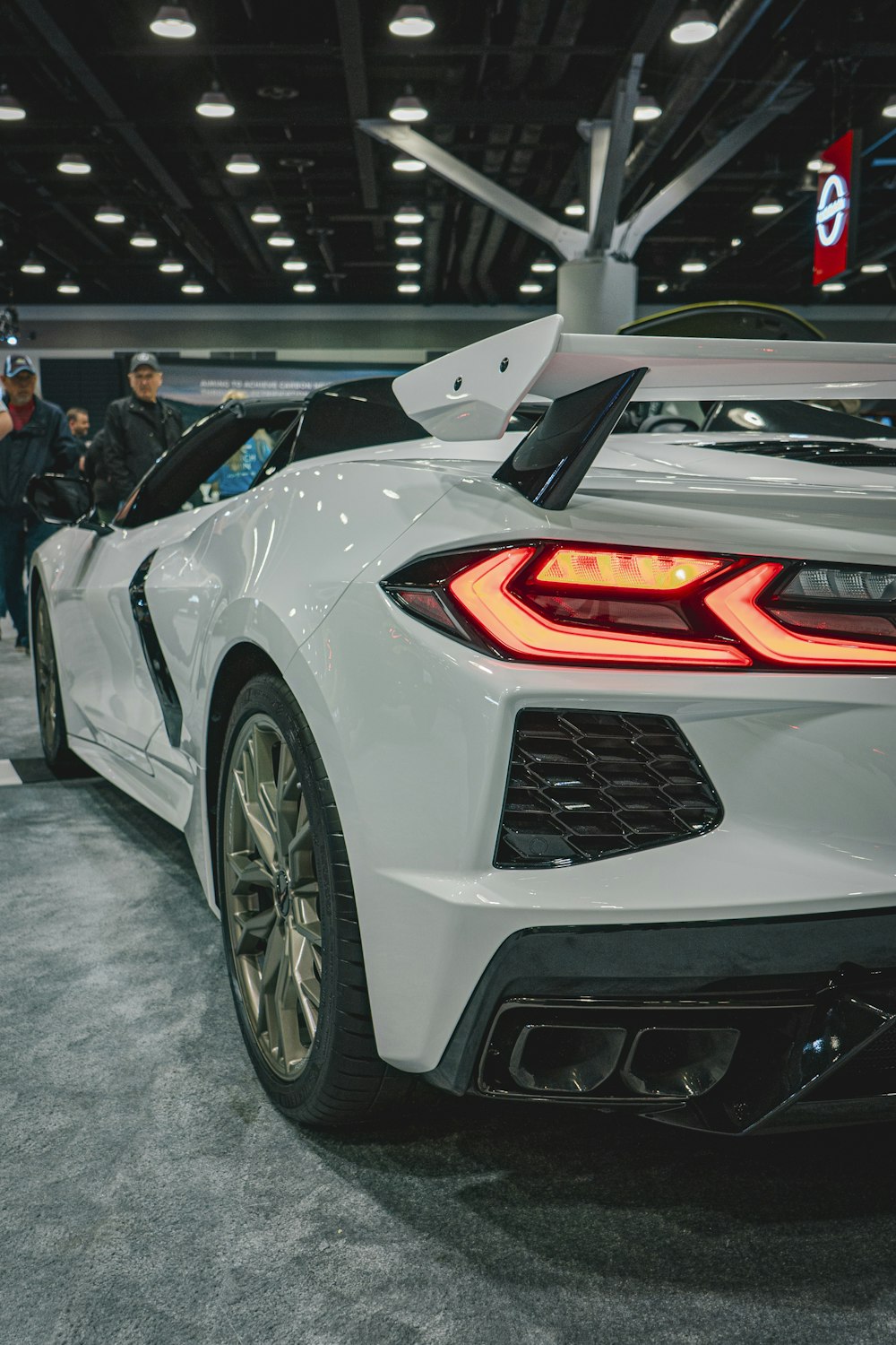 a white sports car is on display at a car show