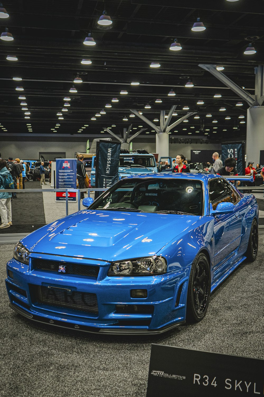 a blue car is parked in a showroom