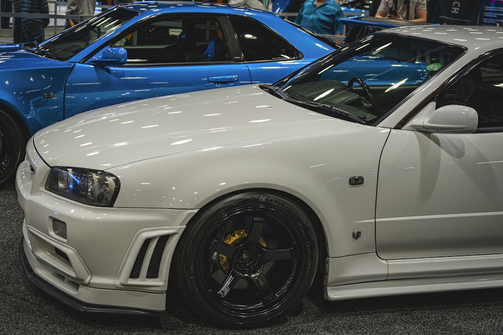 a white car parked next to a blue car