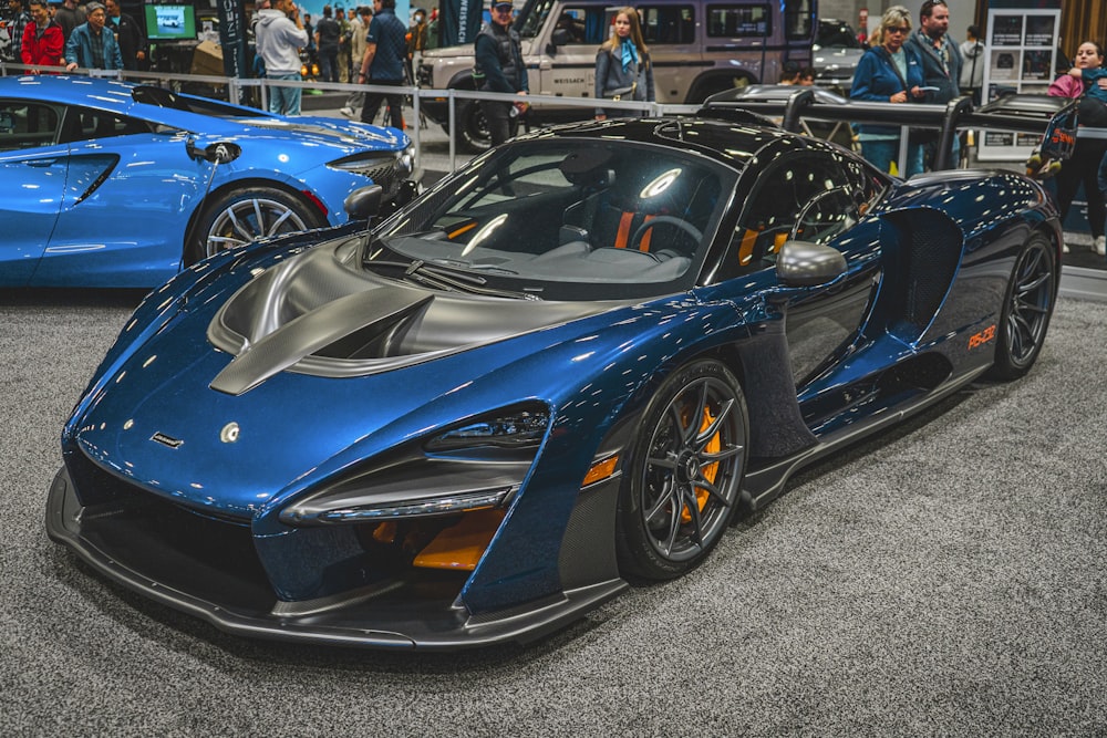 a blue sports car is on display at a car show