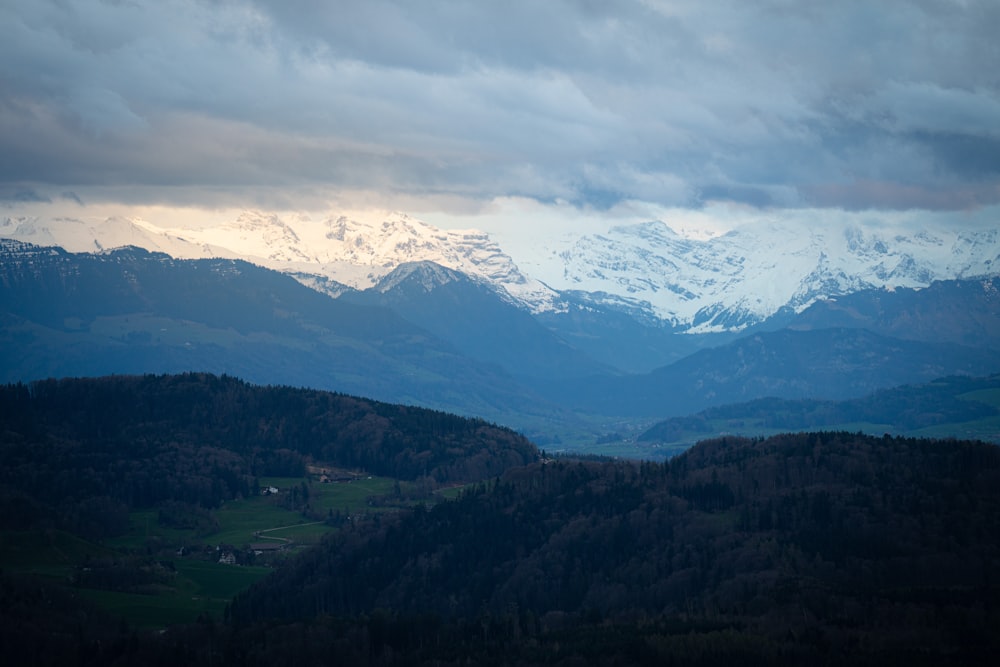 a mountain range with snow capped mountains in the distance