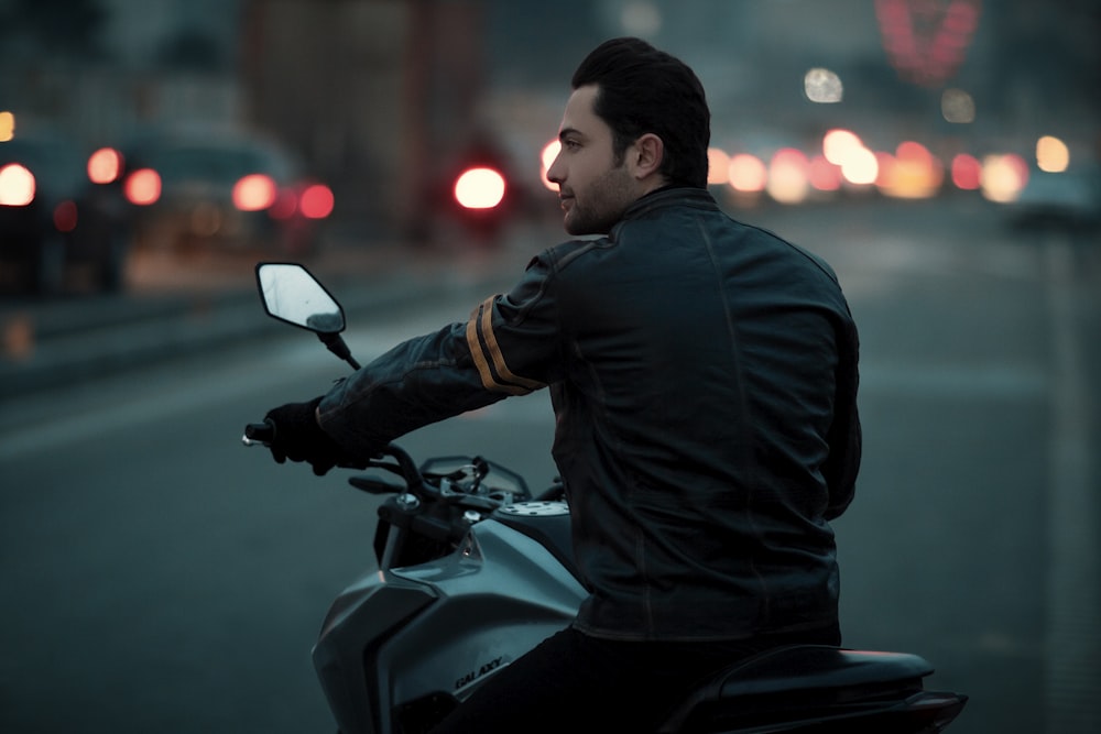 a man riding a motorcycle down a street at night