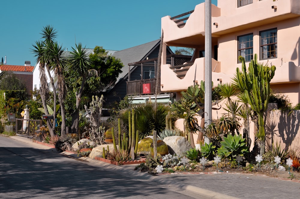 a pink building with a lot of plants in front of it