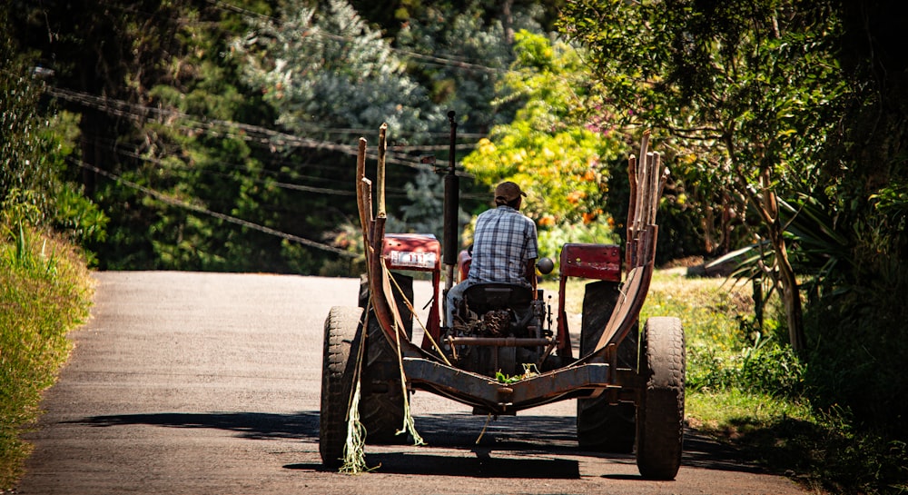 a man driving a tractor down a dirt road