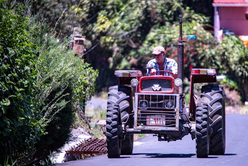 Un hombre conduciendo un tractor por una calle