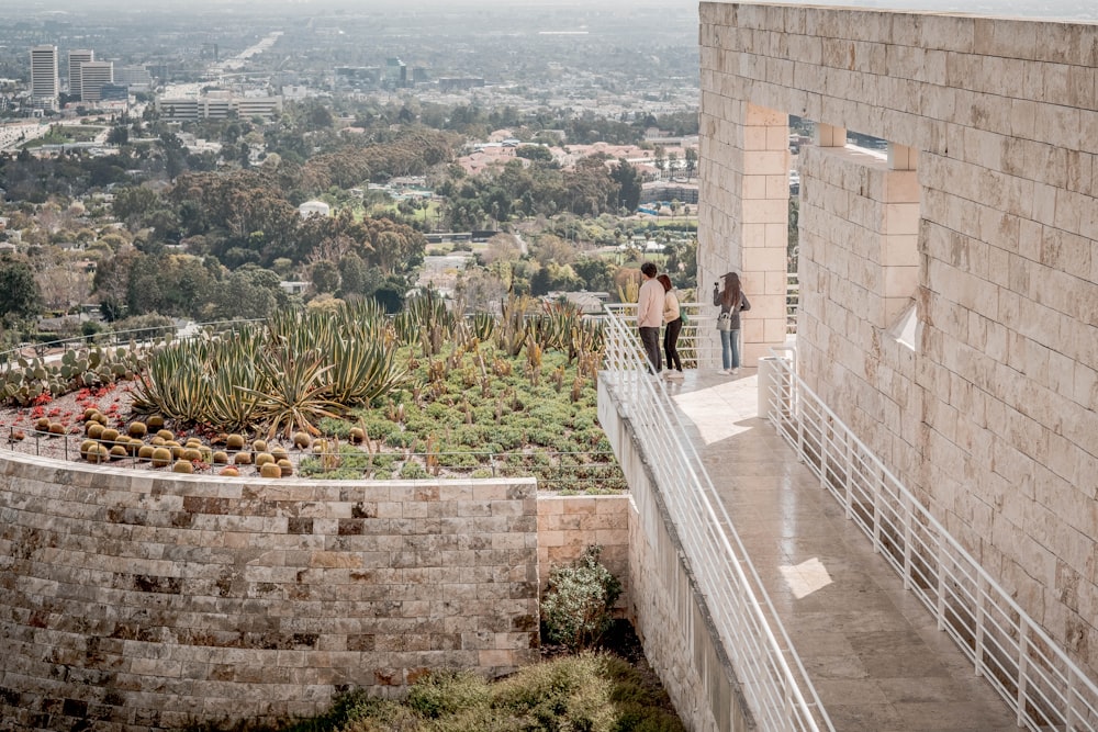 a couple of people that are standing on a ledge