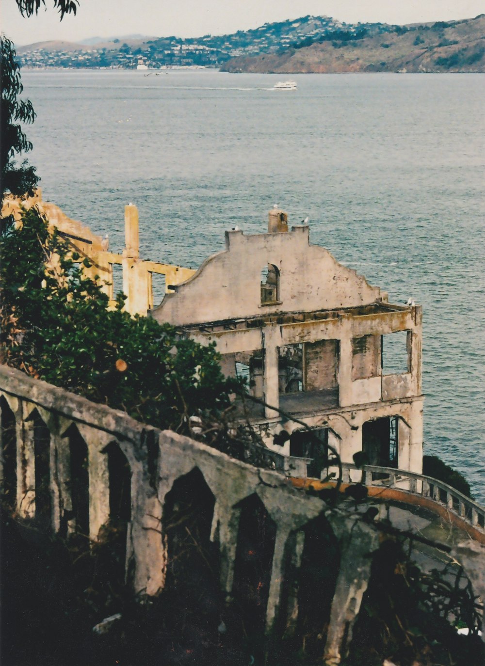 an old house sitting on top of a cliff next to a body of water