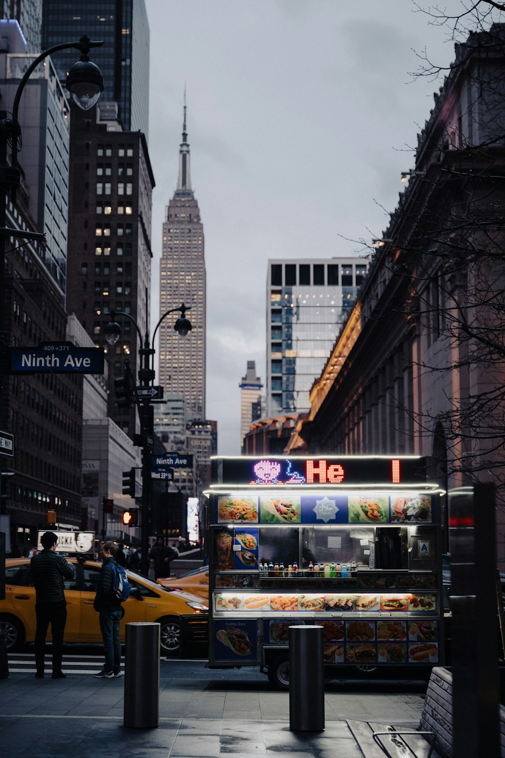 a food stand on a city street with tall buildings in the background