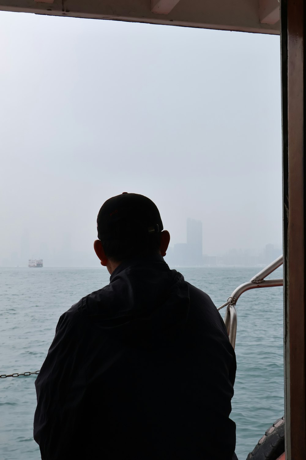 a man sitting on a boat looking out at the water