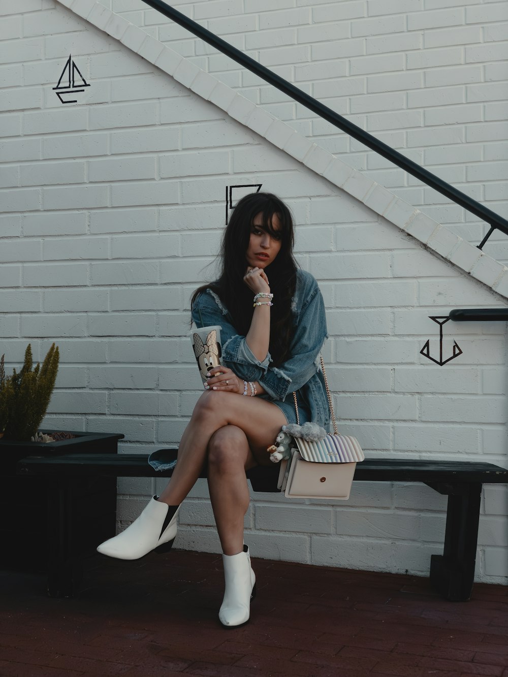 a woman sitting on a bench with a handbag