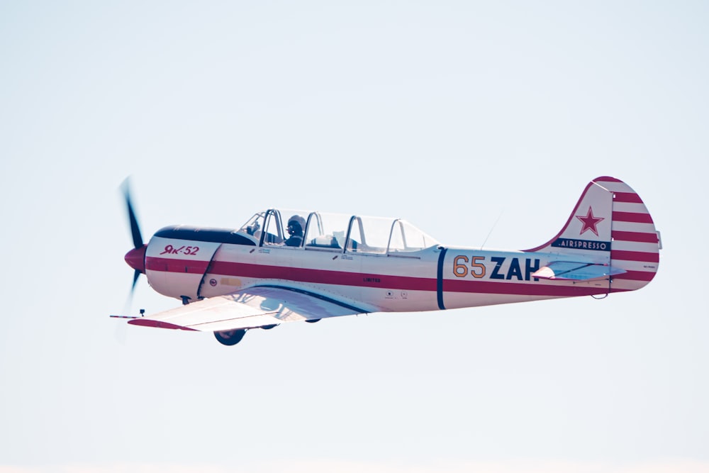 a small airplane flying through a blue sky