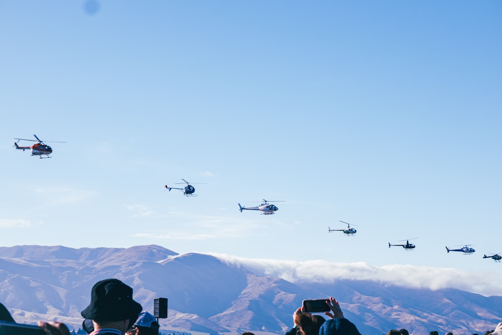 a group of people standing in front of a mountain