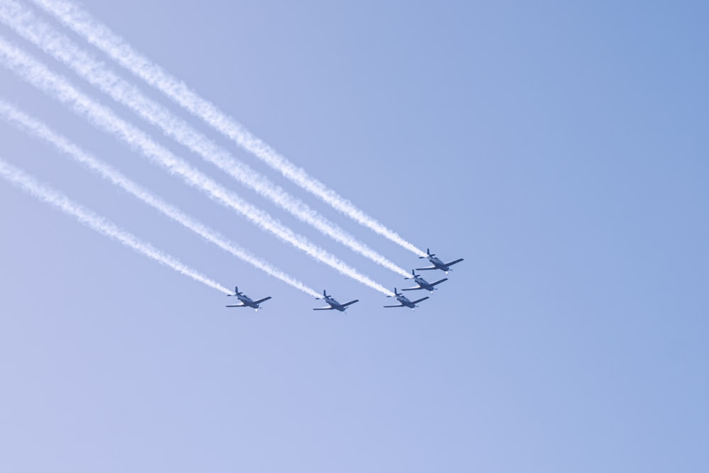 a group of jets flying through a blue sky