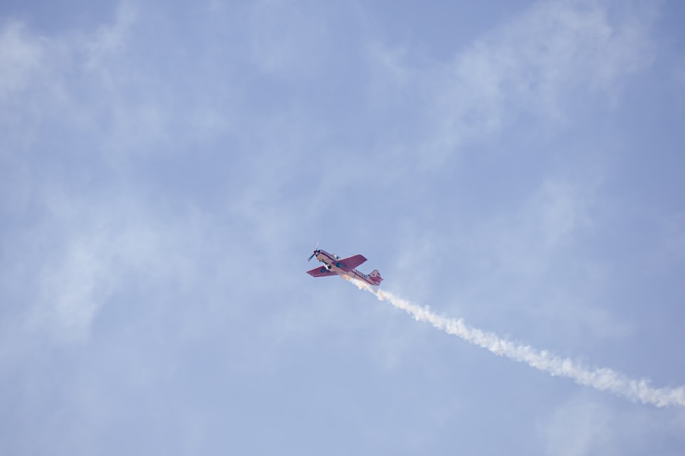 a small plane flying through a blue sky