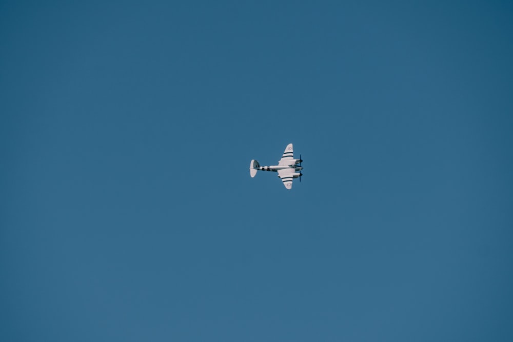 un piccolo aeroplano che vola attraverso un cielo blu