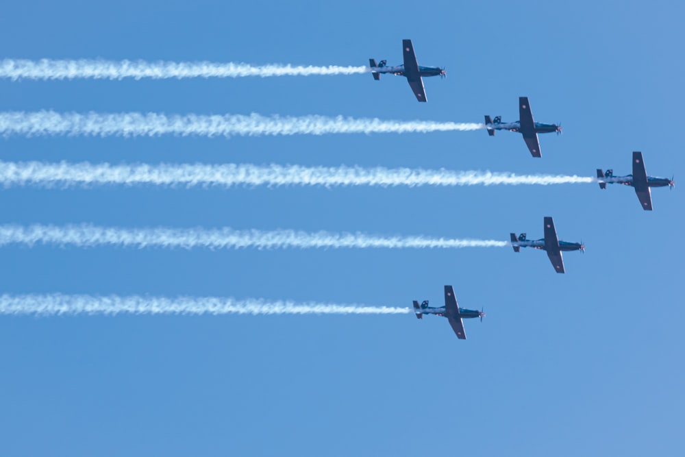 four airplanes flying in formation in a blue sky