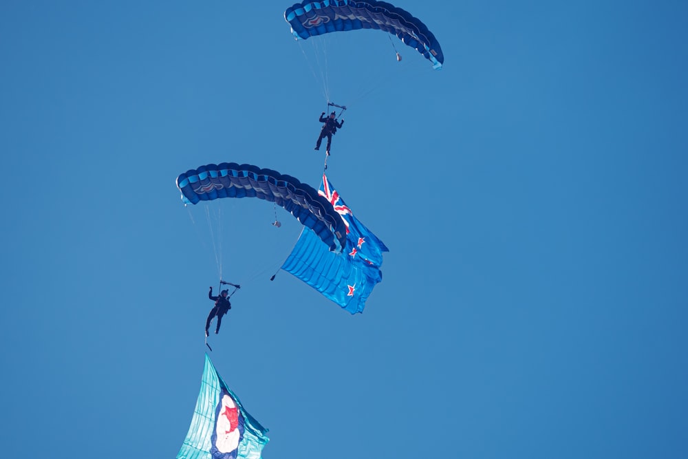 Dos personas están haciendo parasailing en el cielo azul