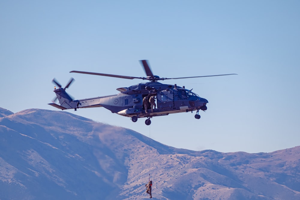 a helicopter is flying over a mountain range