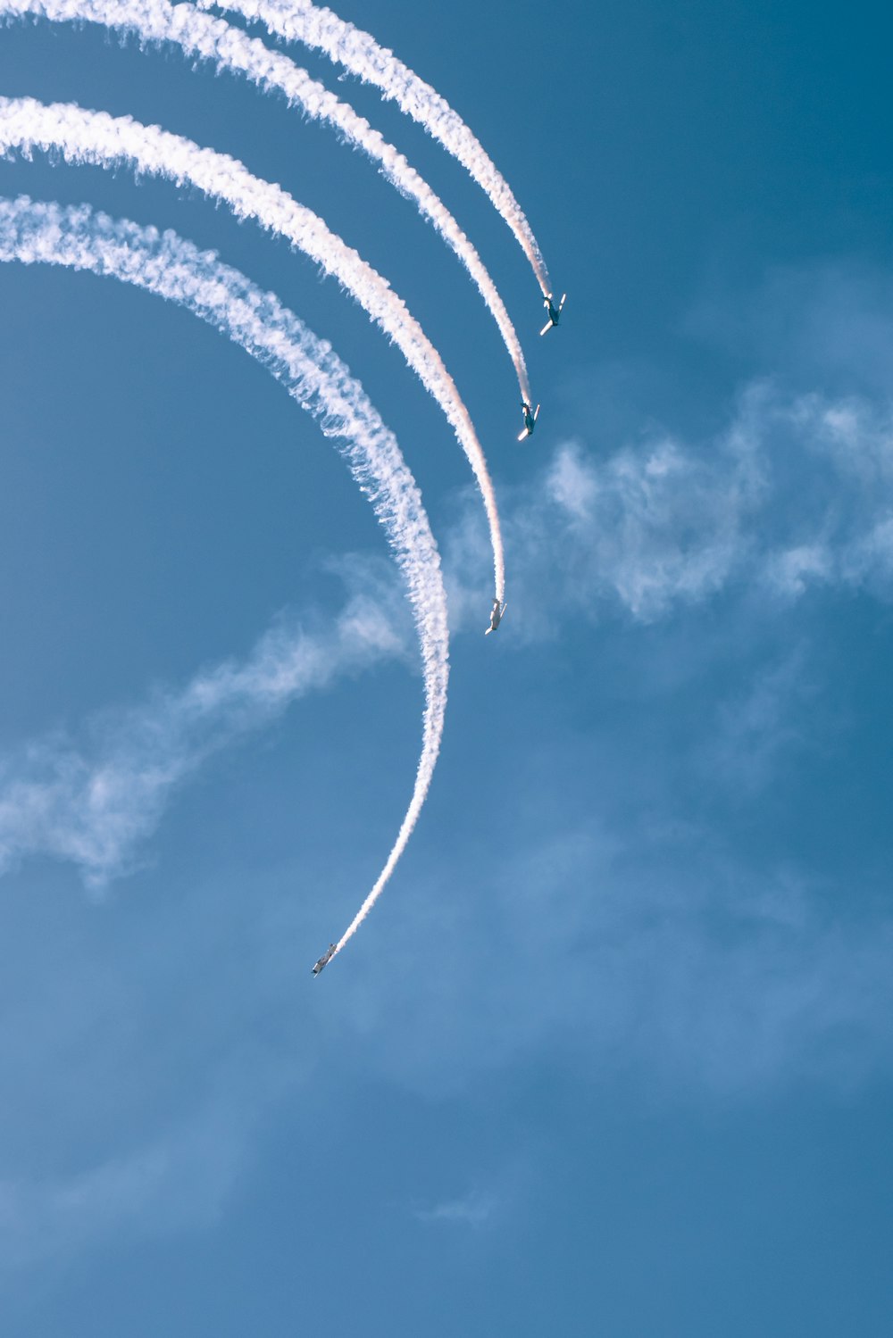 a group of jets flying through a blue sky