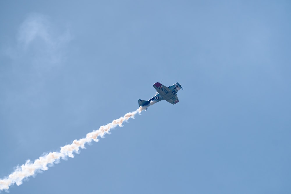 a small plane flying through a blue sky