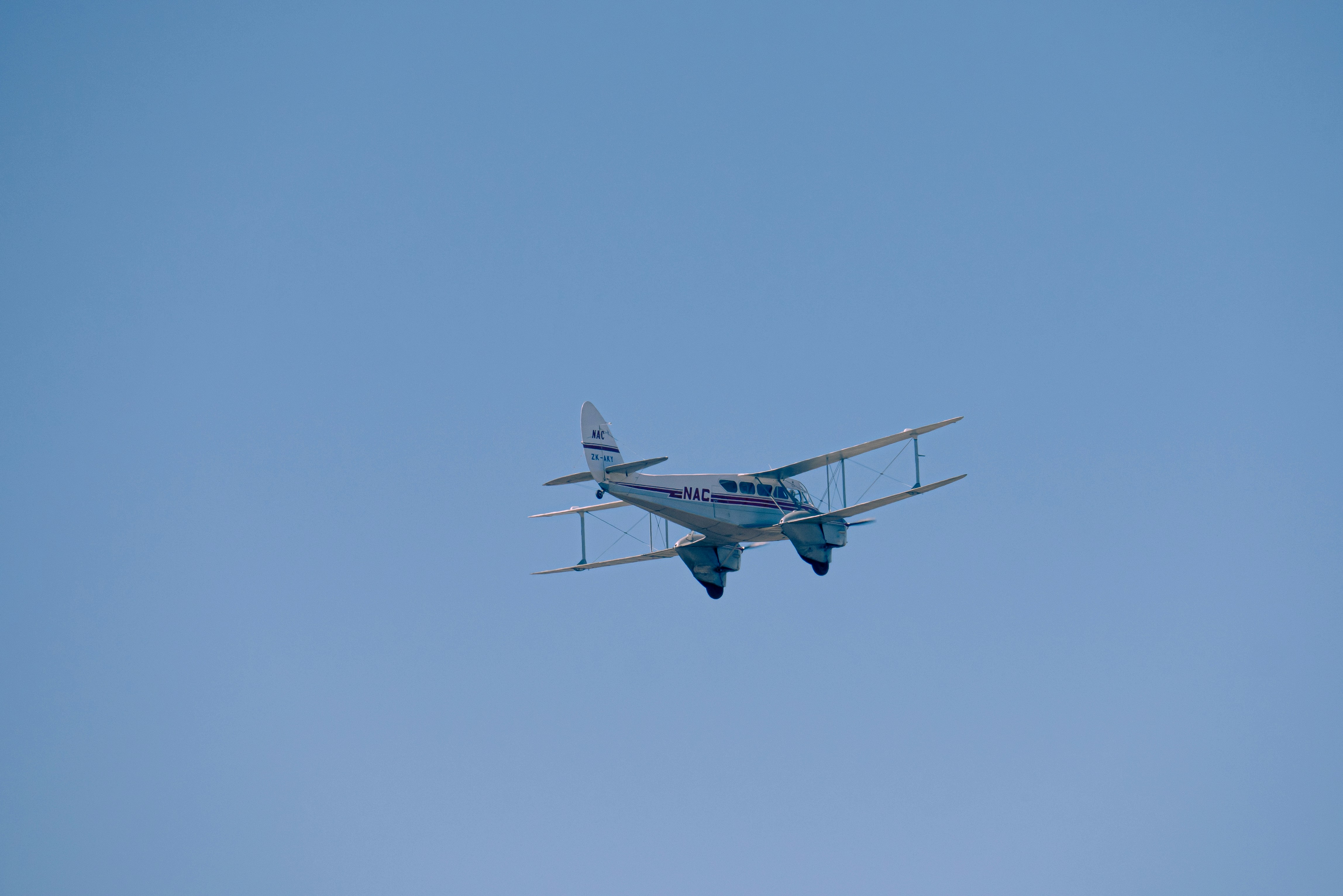 a small airplane flying through a blue sky, 