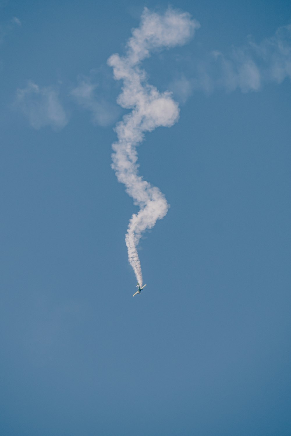 a plane is flying in the sky leaving a trail of smoke