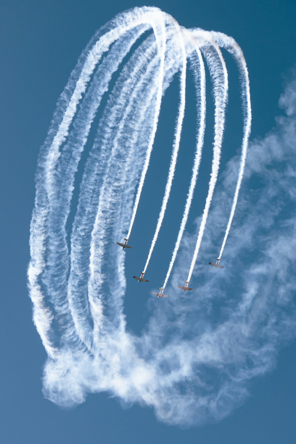 a group of airplanes flying through a blue sky