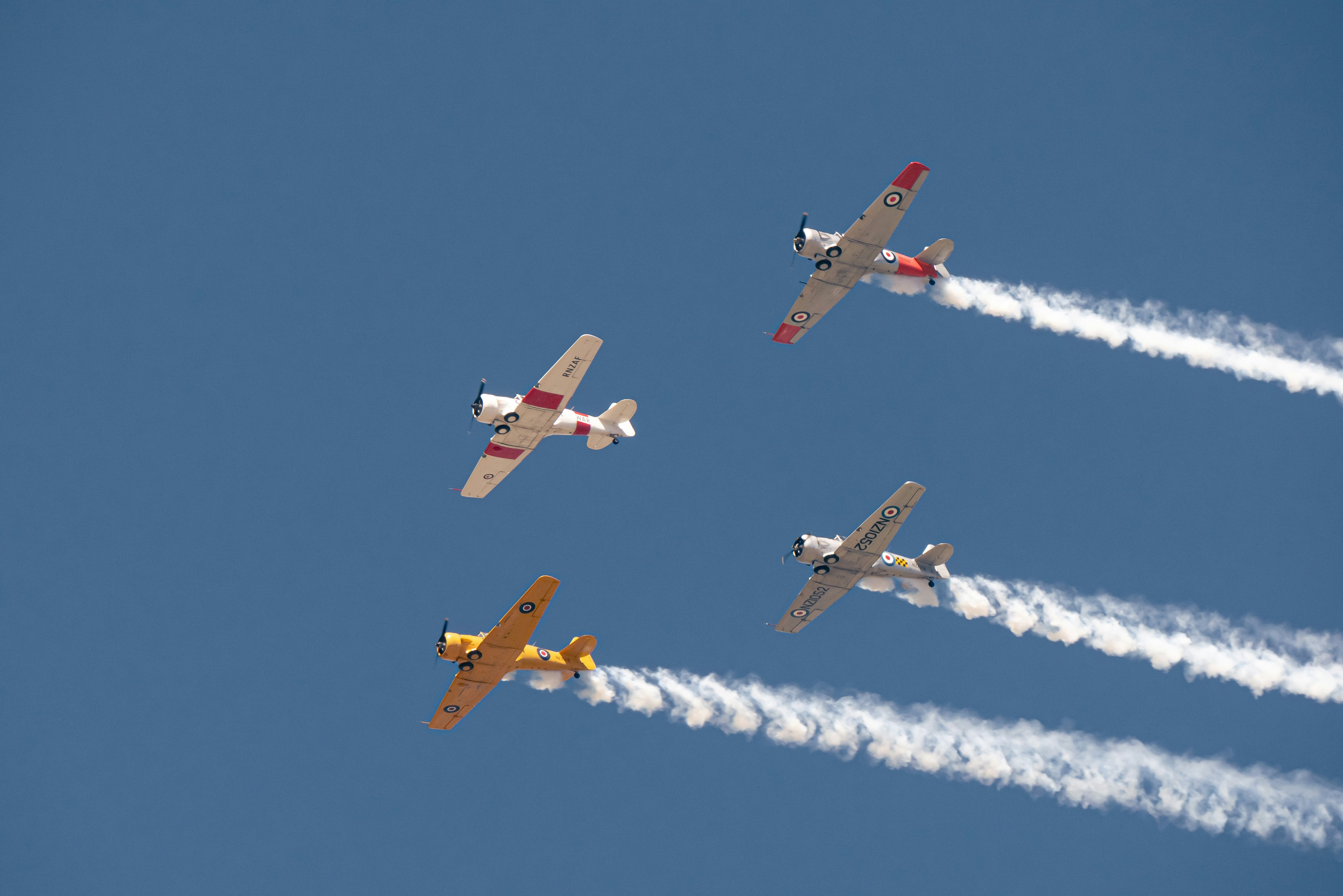 a group of airplanes flying through a blue sky, 