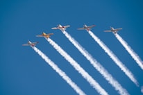 a group of airplanes flying through a blue sky