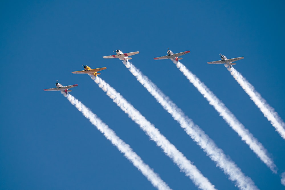 a group of airplanes flying through a blue sky