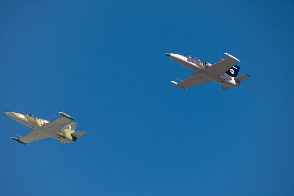 two planes flying side by side in the sky