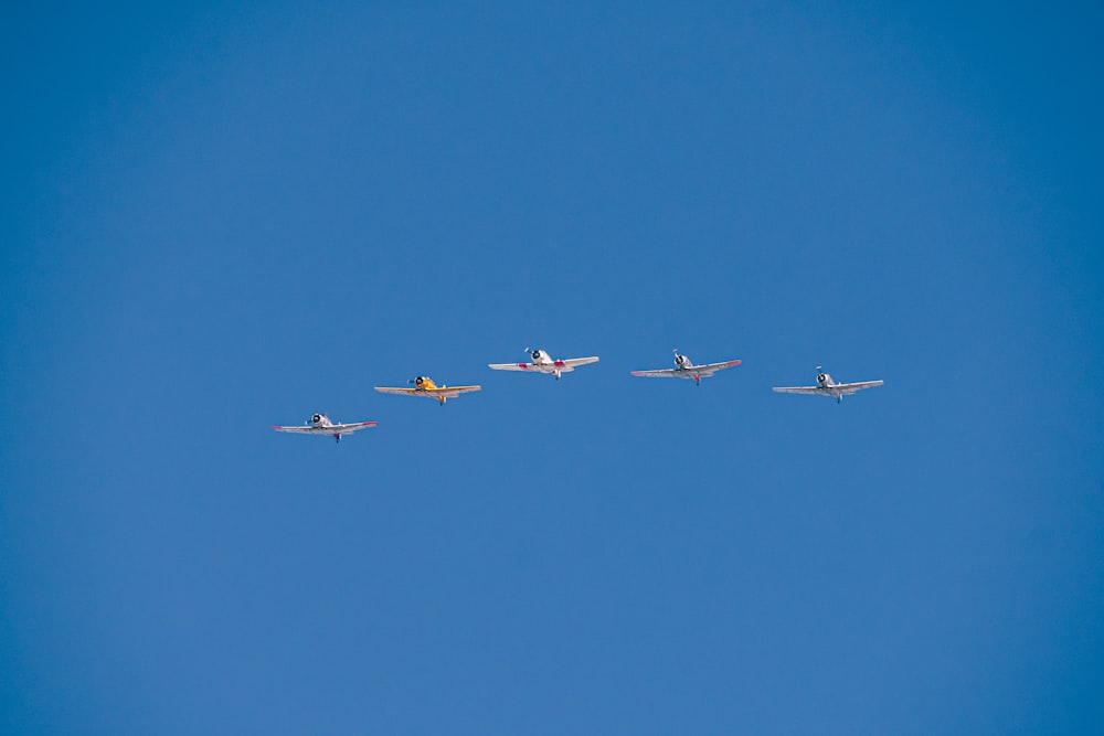 a group of airplanes flying through a blue sky