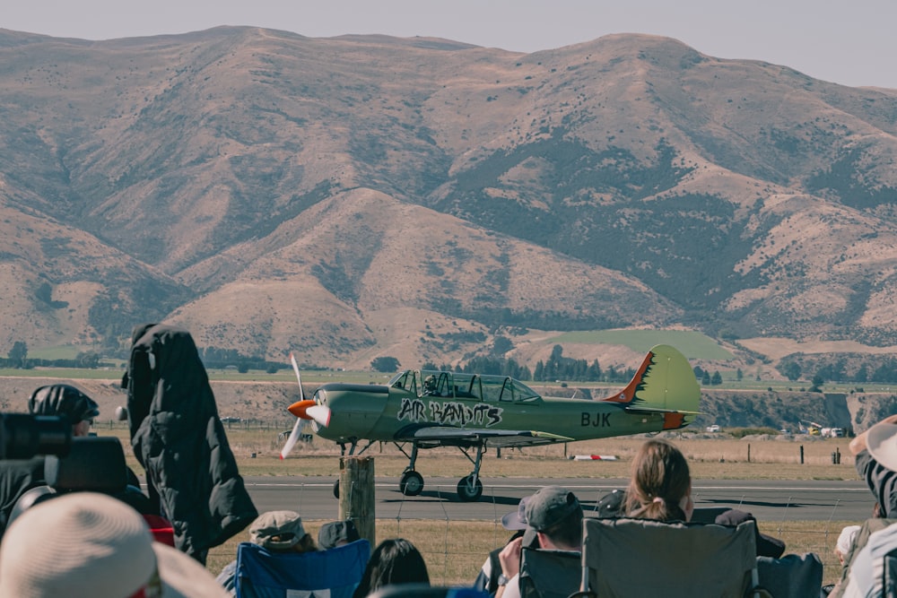 um grupo de pessoas sentadas em cadeiras observando um avião