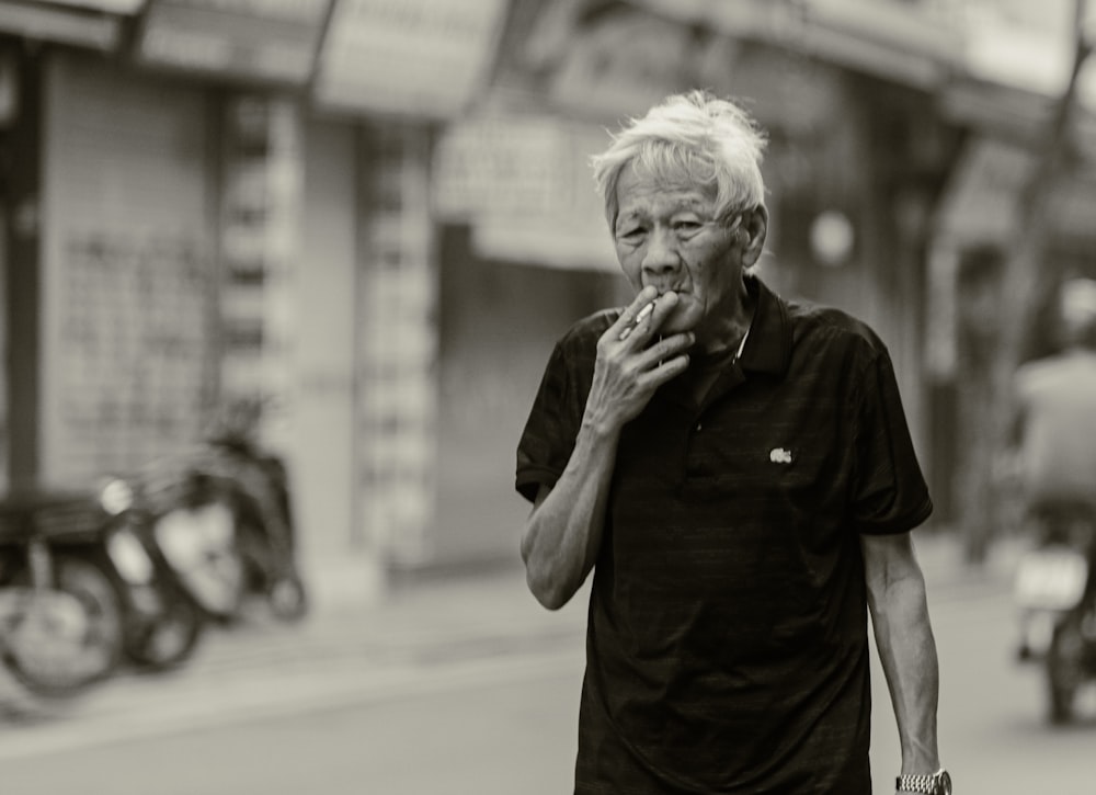 ein Mann, der eine Straße entlanggeht, während er ein Stück Essen isst