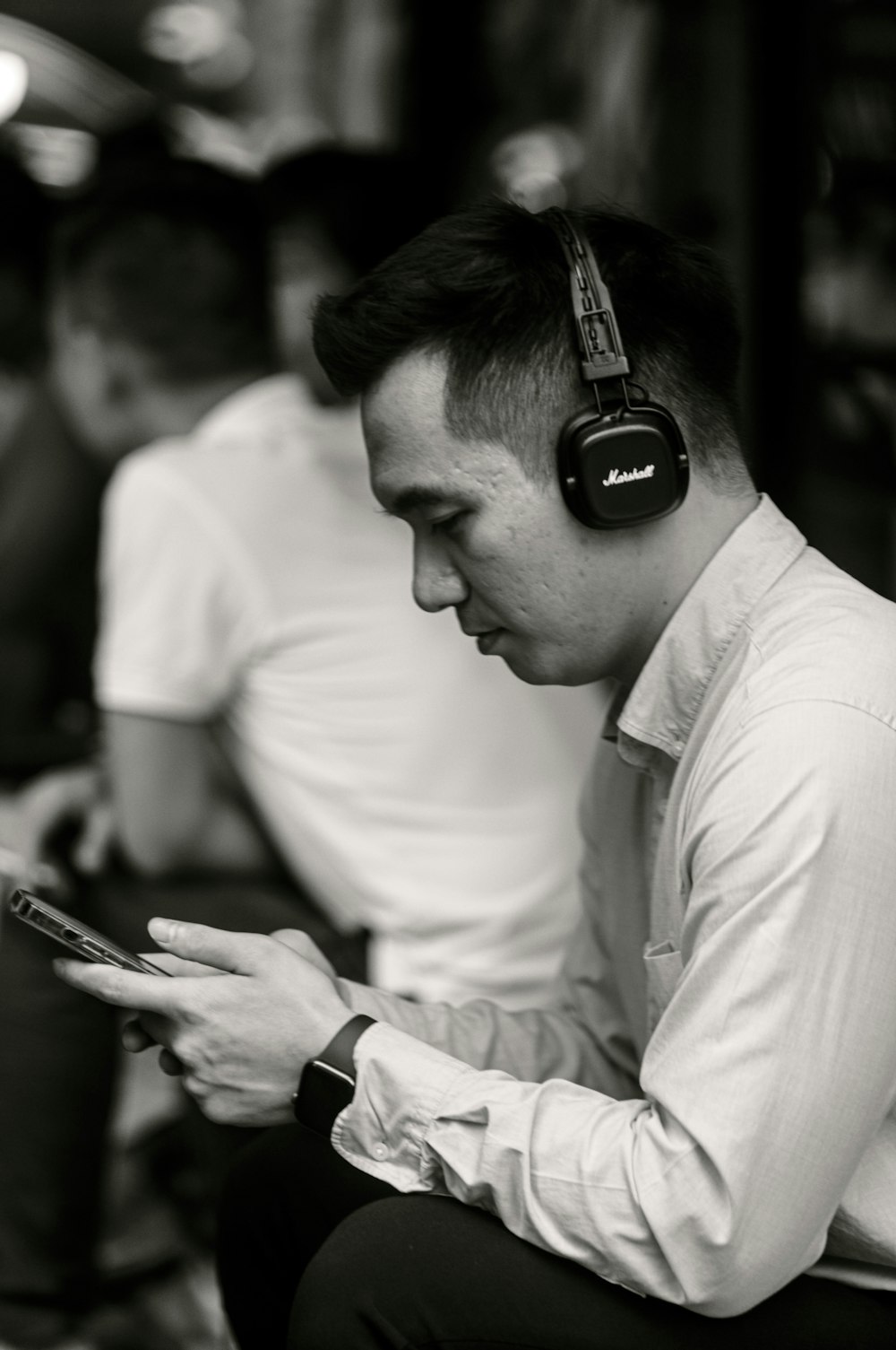 a man with headphones on looking at his cell phone