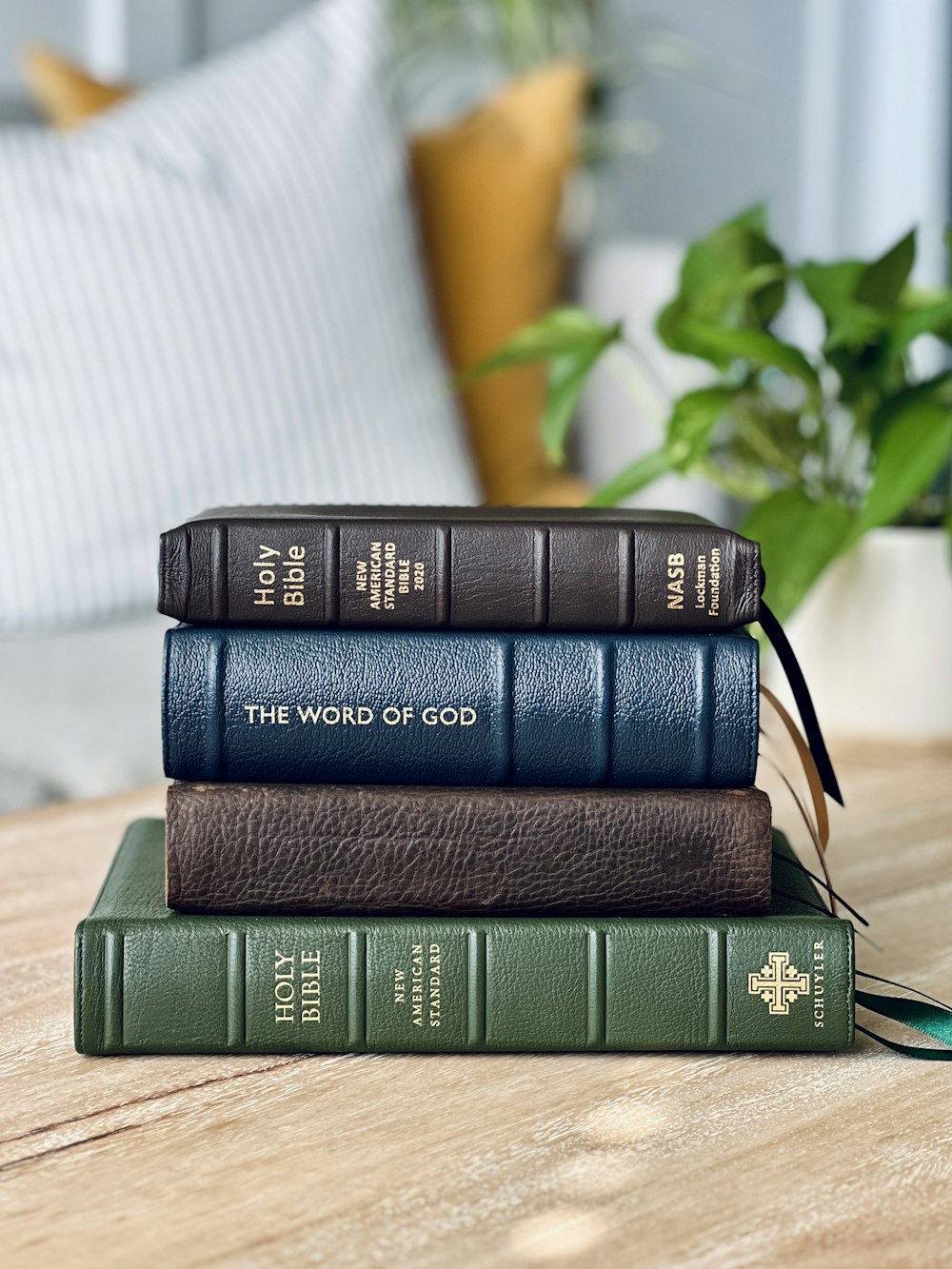 a stack of three books sitting on top of a wooden table