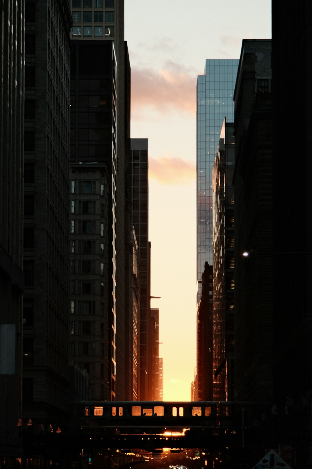 the sun is setting in a city with tall buildings